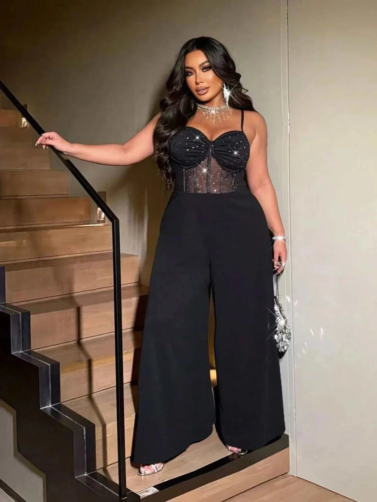 Plus-size women's sexy black jumpsuit with rhinestone-embellished sheer corset bodice, sweetheart neckline and wide legs.
