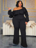 Elegant Woman Jumpsuit in black fabric, featuring an off-shoulder ruffled neckline, long sleeves and a wide-leg silhouette.