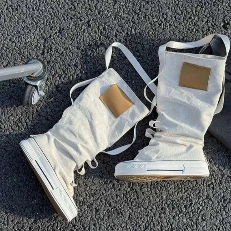Urban Rebel High-Top Statement Boots in white canvas, with slouchy lace-up shafts, white soles and tan rectangular patches.